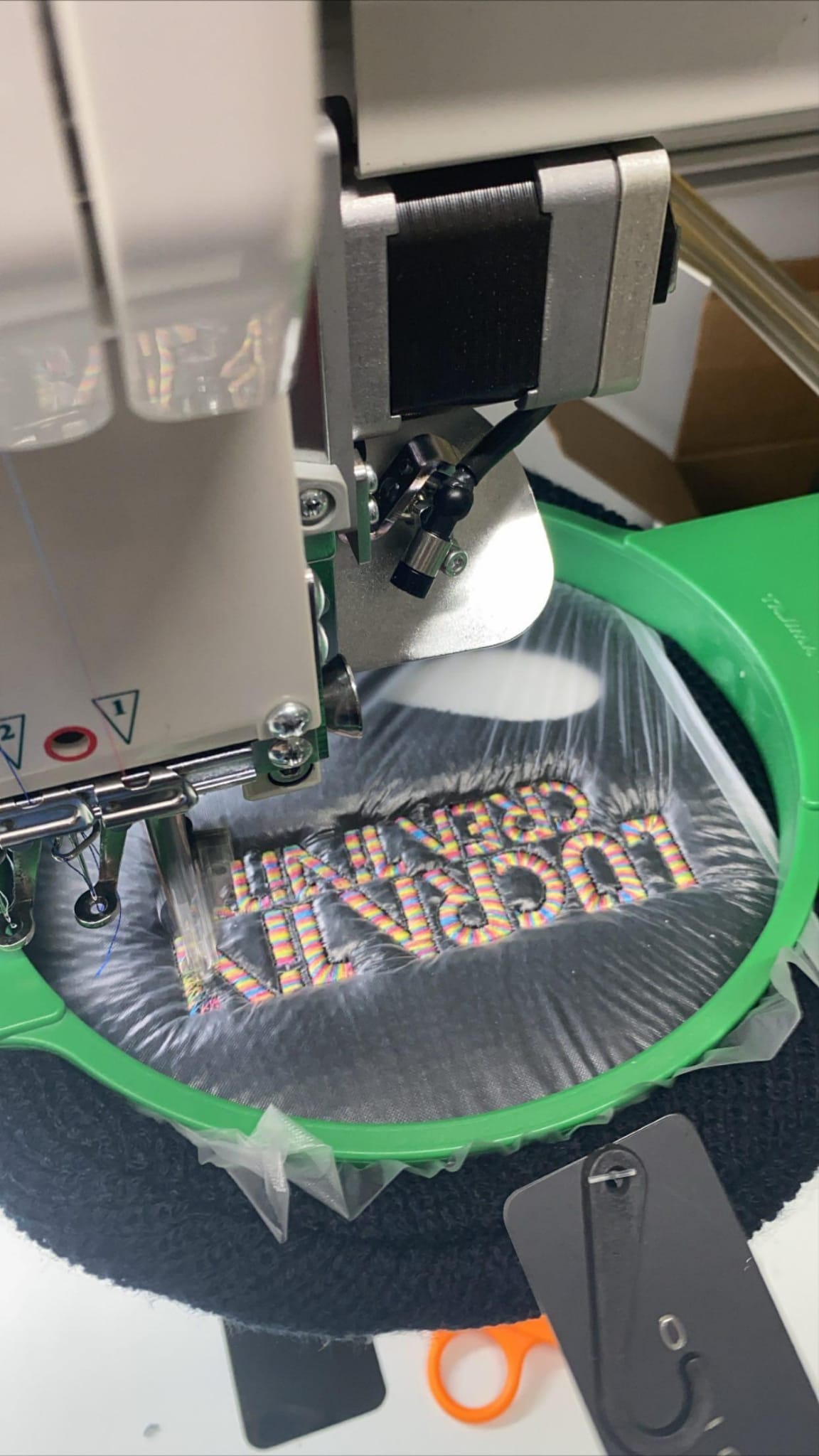 Lucrative Creativity lettering being embroidered by machine