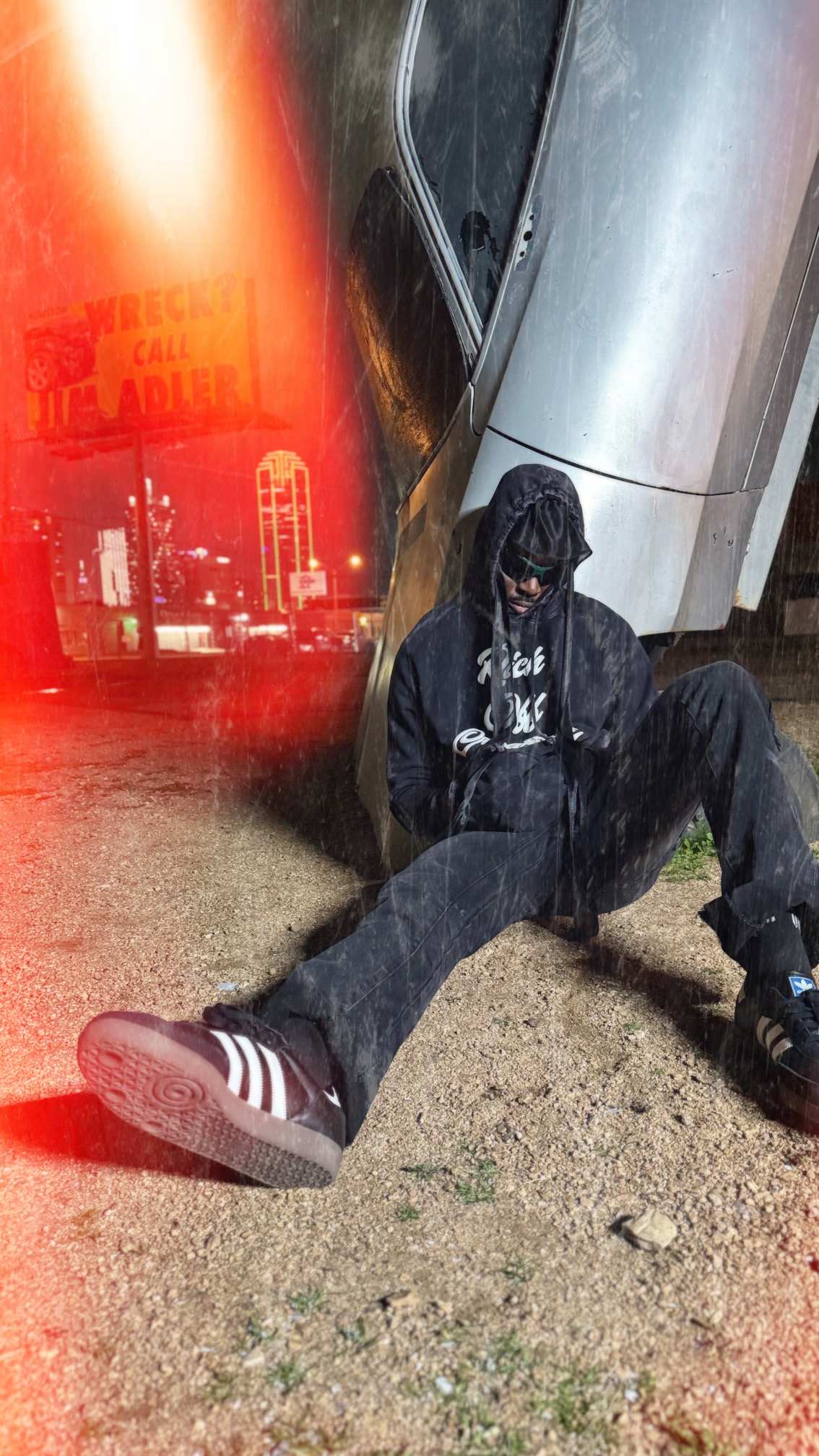 Creative wearing the washed black Rich Off Creativity hoodie in a Dallas night setting