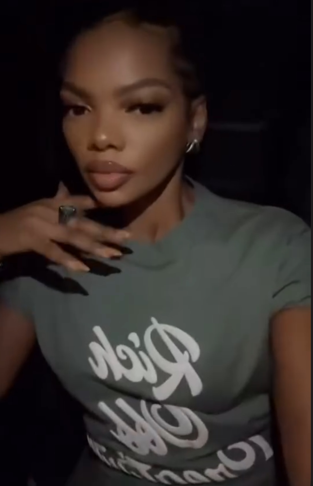 Woman wearing a grey Rich Off Creativity T-shirt in a nighttime portrait